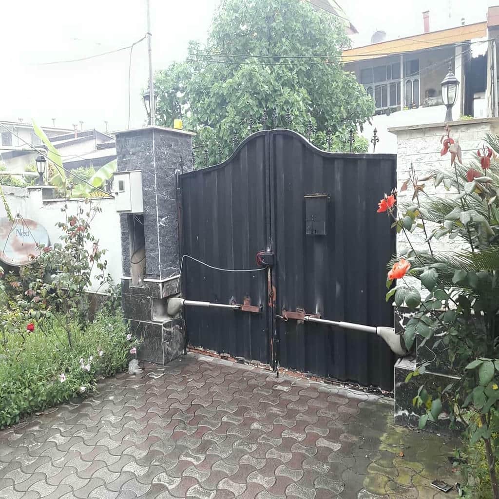 جک درب پارکینگ خاکستری روی دروازه چوبی ویلا در ارومیه