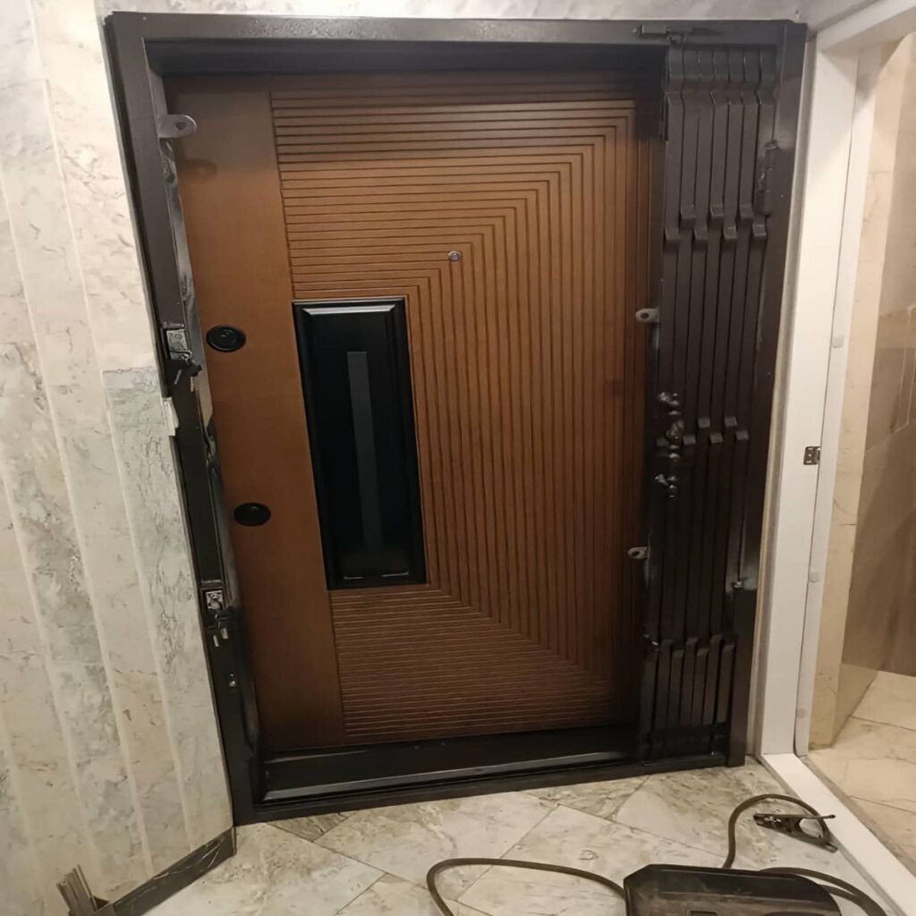 حفاظ درب آکاردئونی قهوه‌ای مقابل چارچوب سنگی