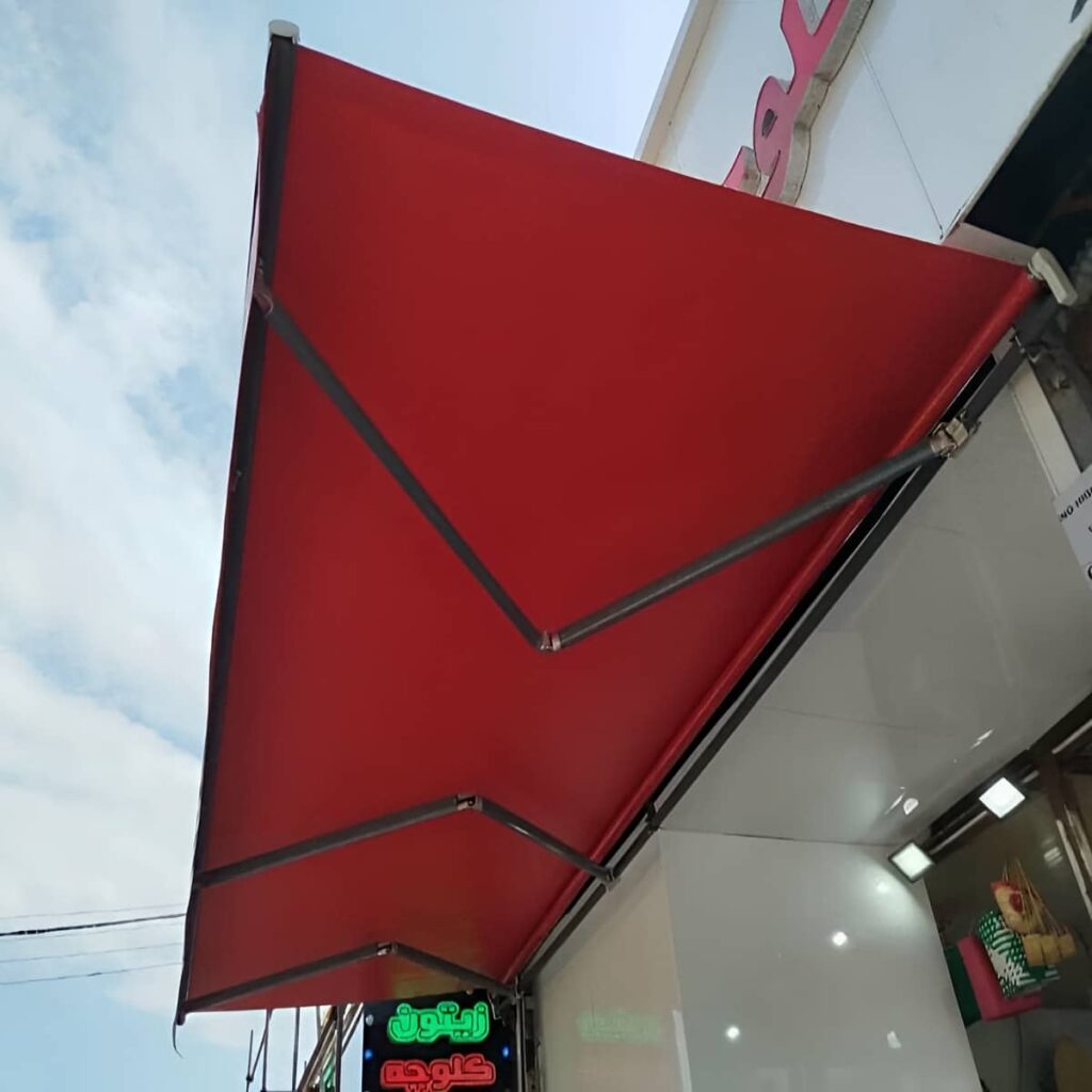سایه بان بازویی کرم بالای سردر فروشگاه سایه بان بازویی کرم بالای سردر فروشگاه