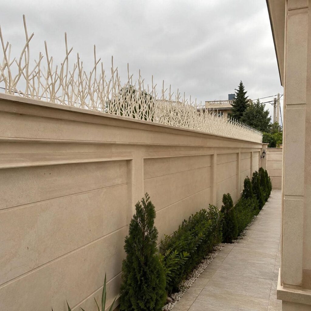 نرده سرنیزه‌ای با پوشش طوسی روی حصار آجری