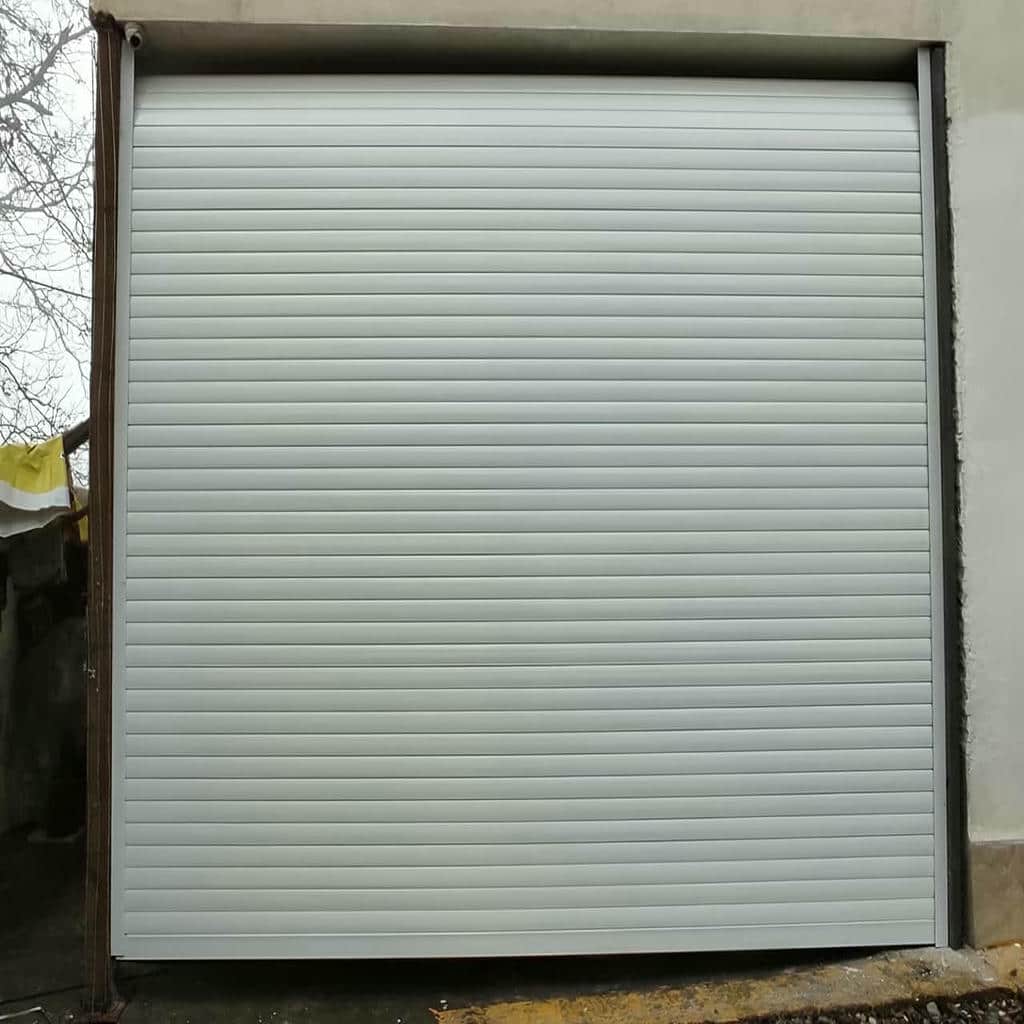 کرکره اتوماتیک نقره ای کنار نمای سنگی مجتمع مسکونی
