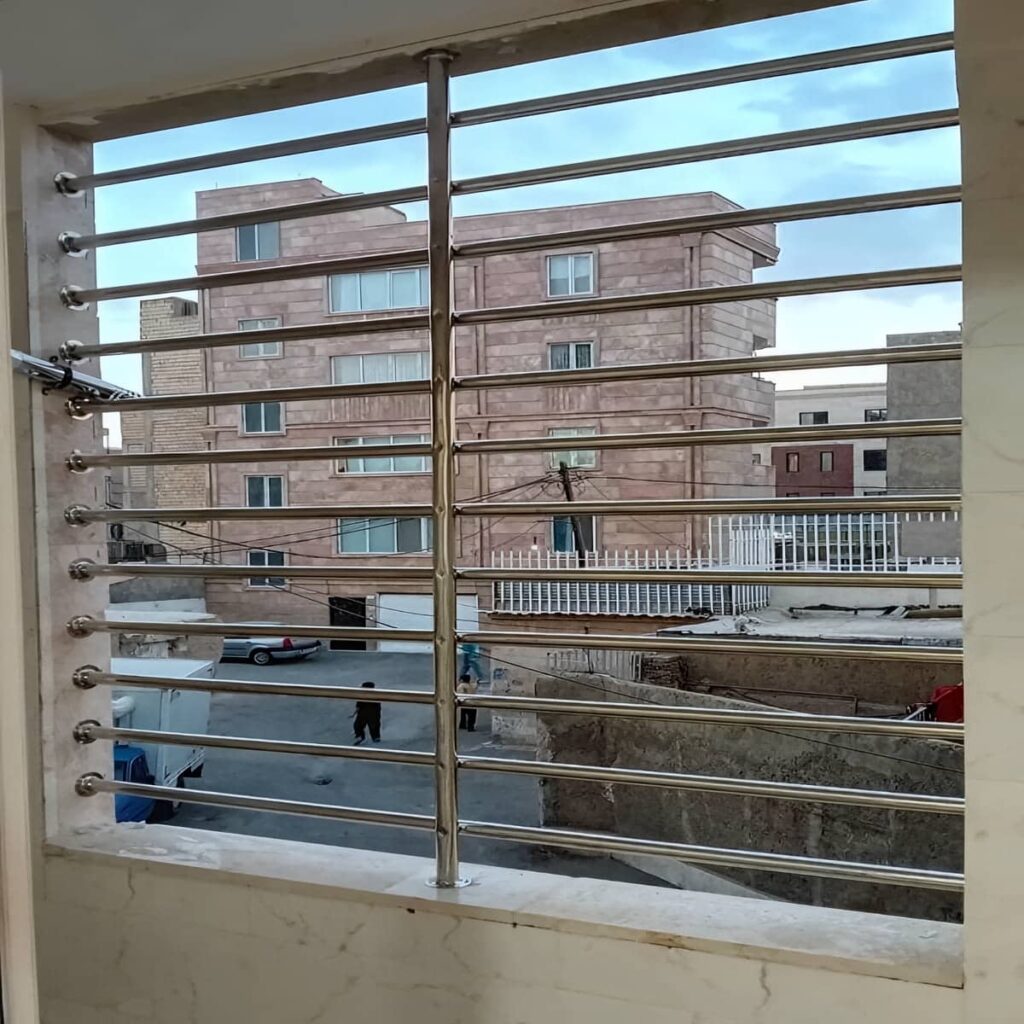 گارد پنجره خاکستری با قاب چهارگوش بر دیوار سیمانی بیرجند